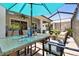 The lanai features a dining table, ceiling fan, shade umbrella, and comfortable outdoor seating at 13357 Waterleaf Garden Cir, Riverview, FL 33579
