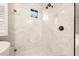Modern shower with marble tile surround, rainfall shower head, and decorative tile floor at 14019 Nighthawk Ter, Lakewood Ranch, FL 34202