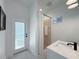 Bright bathroom featuring white vanity, walk-in shower, and exterior door to the pool at 14019 Nighthawk Ter, Lakewood Ranch, FL 34202