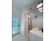 Bright bathroom featuring white vanity, walk-in shower, and exterior door to the pool at 14019 Nighthawk Ter, Lakewood Ranch, FL 34202