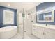 Well-lit bathroom featuring a soaking tub, glass shower, and white cabinets at 14019 Nighthawk Ter, Lakewood Ranch, FL 34202