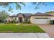 Charming home with a manicured lawn, stone accents, and a brick driveway at 14019 Nighthawk Ter, Lakewood Ranch, FL 34202