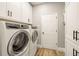 Laundry room featuring white cabinetry and modern washer and dryer at 14019 Nighthawk Ter, Lakewood Ranch, FL 34202