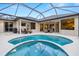 Backyard with a luxurious swimming pool and spa, surrounded by a screened-in patio at 14019 Nighthawk Ter, Lakewood Ranch, FL 34202