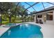 Backyard featuring a tranquil pond view, lush landscaping, pool and comfortable seating area at 14019 Nighthawk Ter, Lakewood Ranch, FL 34202