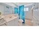 Bright bathroom featuring a shower/tub combo with a blue patterned shower curtain at 1408 Dartmouth Dr, Holiday, FL 34691