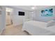 Comfortable bedroom with connecting bathroom, light wood floors and a ceiling fan at 1408 Dartmouth Dr, Holiday, FL 34691
