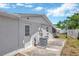 Side view of the house featuring a backyard patio, utility connections and a door at 1408 Dartmouth Dr, Holiday, FL 34691