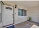 Close up of front door featuring a sidelight window, white door, and brick detailing at 1408 Dartmouth Dr, Holiday, FL 34691