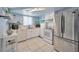 Well-lit kitchen with white appliances, ample cabinet space, and a tiled floor, ideal for cooking and meal preparation at 1408 Dartmouth Dr, Holiday, FL 34691