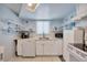 Efficient kitchen with white cabinetry, open shelving, and tiled flooring at 1408 Dartmouth Dr, Holiday, FL 34691