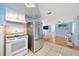 Bright kitchen features stainless steel appliances, white cabinetry, and tiled flooring at 1408 Dartmouth Dr, Holiday, FL 34691