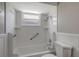 Updated bathroom showcasing a bright shower and tub combination with built-in shelving and safety bars at 1516 Roundtree Rd, Holiday, FL 34690