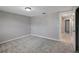 Spacious bedroom with gray carpeting, and bright walls with access to hallway at 1516 Roundtree Rd, Holiday, FL 34690