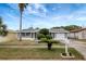 Charming single-story home featuring a manicured lawn, solar panels, and inviting curb appeal at 1516 Roundtree Rd, Holiday, FL 34690