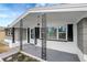 Inviting porch with decorative support columns and modern hanging light fixture at 1516 Roundtree Rd, Holiday, FL 34690