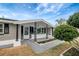 Charming porch with decorative support columns, modern lighting and landscape at 1516 Roundtree Rd, Holiday, FL 34690