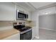 Updated kitchen with modern stainless-steel appliances, wood countertops and neutral toned cabinetry at 1516 Roundtree Rd, Holiday, FL 34690