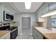 Updated kitchen with modern stainless-steel appliances, wood countertops and neutral toned cabinetry at 1516 Roundtree Rd, Holiday, FL 34690