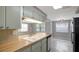 Updated kitchen with modern stainless-steel appliances, wood countertops and neutral toned cabinetry at 1516 Roundtree Rd, Holiday, FL 34690