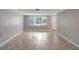 Open-concept living room with light gray walls and tile flooring, showcasing natural light at 1516 Roundtree Rd, Holiday, FL 34690