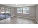 Bright living room with tile flooring, window with blinds and screened-in outdoor patio at 1516 Roundtree Rd, Holiday, FL 34690
