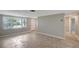 Bright living room with neutral walls, tile flooring, and large windows at 1516 Roundtree Rd, Holiday, FL 34690