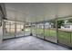 The enclosed patio with grey flooring and many framed windows provides a relaxing view of the backyard at 1516 Roundtree Rd, Holiday, FL 34690