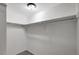 An empty walk-in closet features white walls, carpeted flooring, and a sturdy hanging rod at 1516 Roundtree Rd, Holiday, FL 34690
