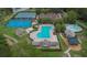 Aerial view of community pool, playground, tennis and basketball courts with lush landscaping and green spaces at 15724 Ibisridge Dr, Lithia, FL 33547