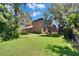 Spacious backyard with green grass, mature trees, and a wrought iron fence at 15724 Ibisridge Dr, Lithia, FL 33547