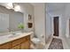 Well-lit bathroom featuring a wooden vanity, toilet, and a shower with curtain at 15724 Ibisridge Dr, Lithia, FL 33547