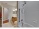 Well-lit bathroom with white-tiled shower/tub and a wood-finished vanity at 15724 Ibisridge Dr, Lithia, FL 33547