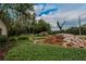 Stone water feature and signage identifying Fiddler's Cove community at entrance with mature trees and landscaping at 15724 Ibisridge Dr, Lithia, FL 33547