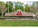 Entrance to Fish Hawk Ranch featuring a stone sign and manicured landscaping at 15724 Ibisridge Dr, Lithia, FL 33547