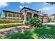 Exterior front elevation of single-story home with arched entry and manicured landscaping and attached garage at 15724 Ibisridge Dr, Lithia, FL 33547