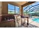 Outdoor kitchen area with built-in grill, sink, mini-fridge, and counter space at 15724 Ibisridge Dr, Lithia, FL 33547