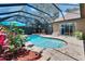 Inviting screened-in pool area with lush tropical landscaping and brick paver deck at 15724 Ibisridge Dr, Lithia, FL 33547