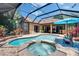 Screened-in pool with attached spa, brick pavers, and outdoor seating area at 15724 Ibisridge Dr, Lithia, FL 33547