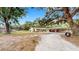 Charming single-story home with a large oak tree, spacious driveway, and unique carport at 1641 Thompson Rd, Lithia, FL 33547