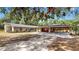 Charming single-story home with a large oak tree, spacious driveway, and unique carport at 1641 Thompson Rd, Lithia, FL 33547