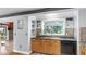 Bright kitchen featuring wood cabinets, black countertops, stainless steel sink, and a large window overlooking the backyard at 1641 Thompson Rd, Lithia, FL 33547