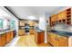 Kitchen with wood cabinets, stainless steel appliances, black countertops, and hardwood floors at 1641 Thompson Rd, Lithia, FL 33547