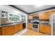 Bright kitchen featuring wood cabinets, stainless steel appliances, and a large window overlooking the backyard at 1641 Thompson Rd, Lithia, FL 33547