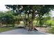 Lush backyard featuring mature trees, a charming swing, and serene water views at 16505 Lake Heather Dr, Tampa, FL 33618