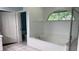 Bright bathroom features a soaking tub with a tiled surround and a garden window at 16505 Lake Heather Dr, Tampa, FL 33618
