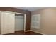 Bedroom with hardwood floors, double closet, and window with shutters at 16505 Lake Heather Dr, Tampa, FL 33618