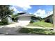 Well-maintained home featuring a spacious driveway, two-car garage, and lush green lawn at 16505 Lake Heather Dr, Tampa, FL 33618
