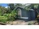 Close up of a blue home with mature landscaping and a well kept garden at 16505 Lake Heather Dr, Tampa, FL 33618