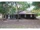 Back of home featuring a large porch, windows and mature trees at 16536 Caldwell Ln, Spring Hill, FL 34610